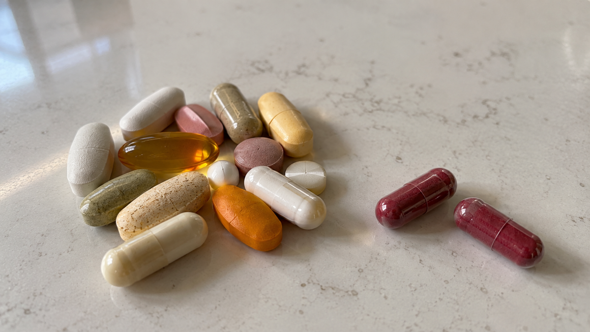 Prescription pills next to two Elivora capsules